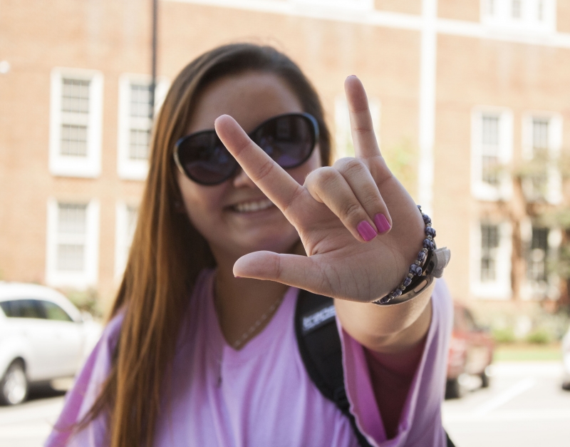 A UA student giving the American Sign Language sign for love.